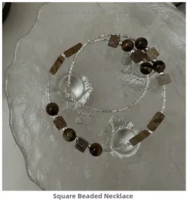Detail of S925 silver necklace with stone beads and heart tag in a glass dish
