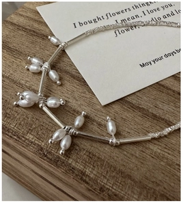 Detail of S925 silver necklace with irregular freshwater pearls on a wooden tray