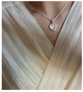 Vue détaillée d'un collier en argent S925 avec pendentif cœur en agate sur un mannequin