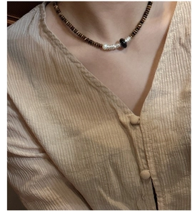 Détail du collier de perles en argent S925 avec perles œil de tigre brunes et perle blanche