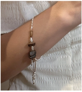 Detail of S925 sterling silver handmade bracelet with natural stones and brown wax cord
