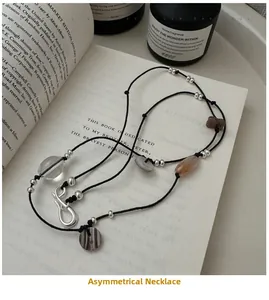 Close-up of handmade irregular beaded necklace with textured beads and dark cord