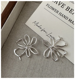 Détail macro de boucles d'oreilles créoles fleur évidée en argent sterling S925