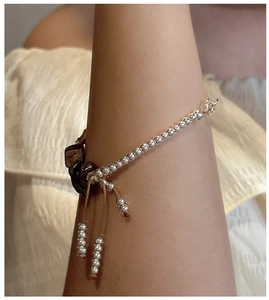 Detail of S925 silver beaded bracelet with natural dark stones and tassel drawstring