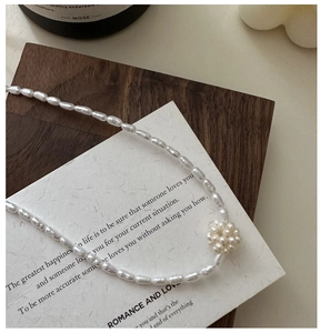 Detailed shot of an S925 silver necklace with freshwater pearls and a woven pearl ball