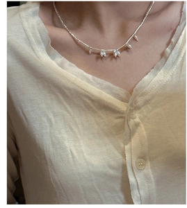 Detailed view of S925 silver necklace with teardrop freshwater pearls on a model