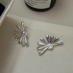 S925 sterling silver daisy petal stud earrings with polished finish on ivory texture