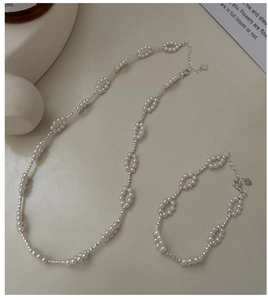 Detail of S925 silver pearl jewelry set featuring circular patterns and heart pendants