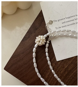Macro view of S925 sterling silver heart tag and toggle clasp on pearl necklace