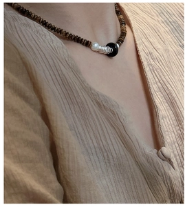 Détail du collier en argent S925 avec perles œil de tigre brunes et perle blanche