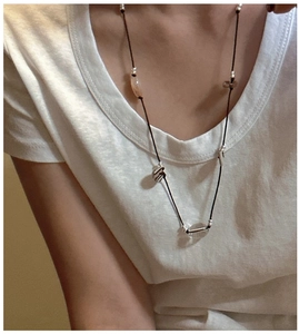 Detail of handcrafted long knot sweater necklace with mixed beads and dark woven cord