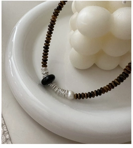 Détail du collier en argent S925 avec perles en bois brun et perle irrégulière