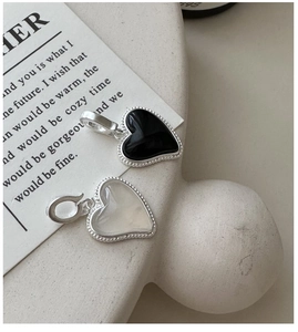 Détail de pendentifs cœur en argent S925 avec agate noire et textures nacre