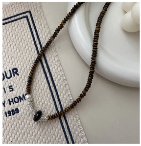 Détail du collier oeil de tigre Maillard avec perles en bois marron et une perle centrale