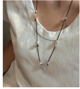 Detail view of handmade S925 silver knotted necklace with ethnic beads on model