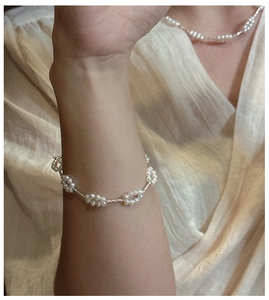 Detail showing S925 sterling silver bracelet with delicate pearl flower clusters on model