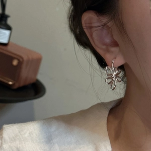 Élégantes boucles d'oreilles créoles fleurs en argent S925 portées par un mannequin