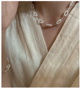 Macro detail of S925 silver pearl necklace and bracelet with elegant floral pattern