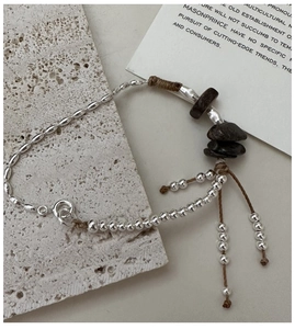 Macro shot of S925 sterling silver beaded bracelet with natural stone and tassels