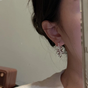 Boucles d'oreilles créoles fleurs évidées en argent S925 portées par un mannequin