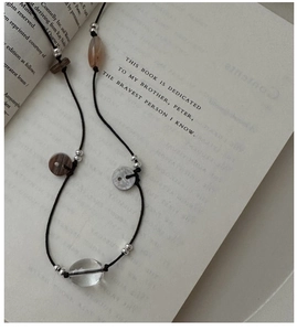 Detail of vintage handmade knotted sweater necklace with beads on an open book