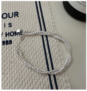 Macro detail of S925 sterling silver double-layer beaded bracelet with heart tag