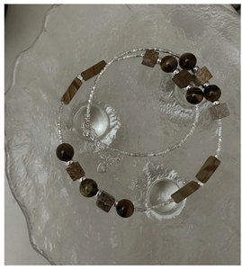 Macro detail of S925 silver beaded necklace with tiger eye stones and heart tag