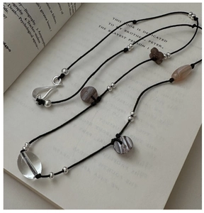 Detailed close-up of handmade beaded long necklace on an open book background
