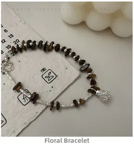 Macro detail of S925 silver tiger eye bead bracelet with floral charm on aesthetic setup