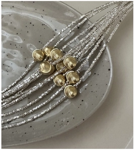 Close-up of S925 silver beaded bracelet with brushed golden spherical metal elements
