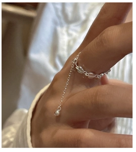 Macro view of S925 sterling silver chain ring with heart link and dangling bead detail