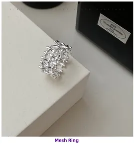 Macro shot of silver woven lattice ring showcasing intricate hollow mesh design detail