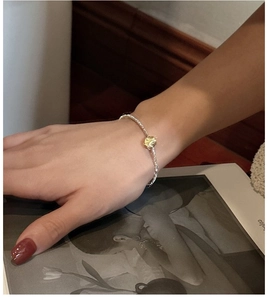 Detail of S925 silver crushed bead bracelet with a golden cat eye charm on wrist