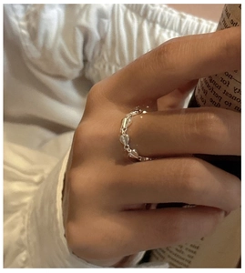 Detail of S925 sterling silver ring with connected 3D hearts on a model's hand