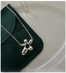 Detail of S925 sterling silver flower pendant with hallmark on green velvet pouch