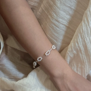Minimalist S925 sterling silver bracelet with delicate pearl flower design on female wrist