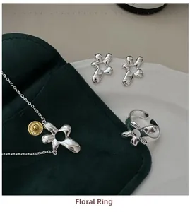 Vue détaillée de la bague fleur en argent S925 et parure de bijoux sur velours vert