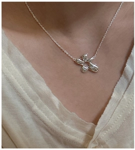 Detail of S925 sterling silver necklace with a minimalist irregular flower pendant on neck