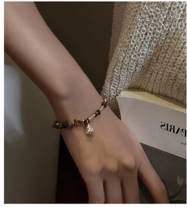 Close-up of S925 silver bracelet with brown tiger eye stone beads on female wrist