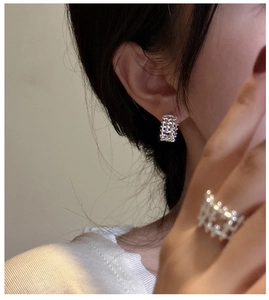 Detailed view of woven mesh S925 sterling silver ring and hoop earrings on model
