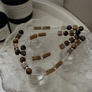 Retro S925 silver necklace with brown tiger eye beads and wooden stone on glass tray