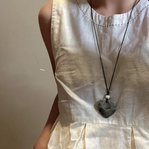 Collana minimalista con ciondolo a cuore in pietra naturale su un cordino nero fine