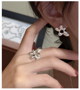 Détail de la bague et boucle d'oreille fleur en argent S925 au design métal fondu