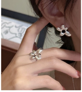 Detailed view of S925 sterling silver floral ring and earrings with dark stone centers