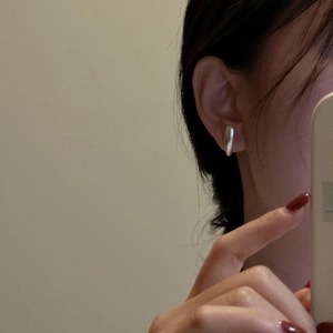 Minimalist S925 sterling silver waterdrop earrings worn on ear with polished finish