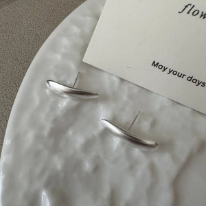 Minimalist S925 sterling silver matte teardrop stud earrings on a white porcelain plate