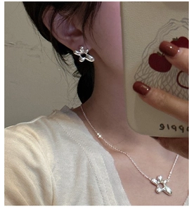 Detailed shot of S925 silver irregular floral earrings and necklace set on a model