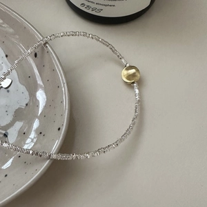 Minimalist S925 silver bracelet featuring crushed silver links and a gold cat-eye bead