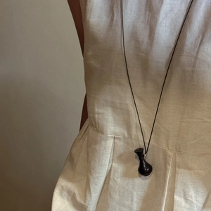 Collana minimalista in argento S925 con ciondolo a bottiglia su abito in lino