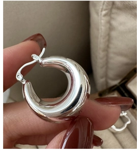Polished S925 sterling silver hoop earring held in hand with premium glossy finish